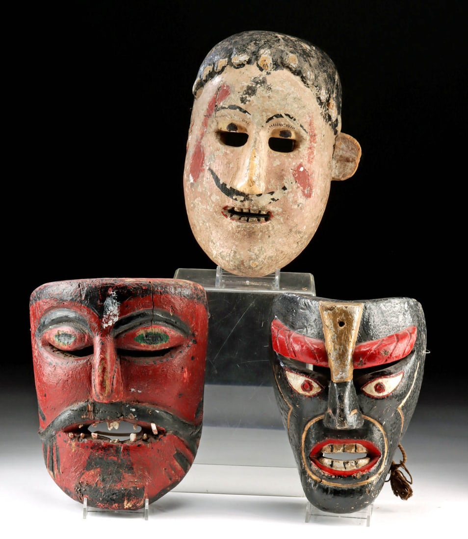 Three Mexican Polychrome Wood Festival Dance Masks: Latin America, Mexico / Guatemala, ca. early to mid-20th century CE. This collection features three hand-carved and painted wooden festival masks, each with grotesque and exaggerated features, traditi
