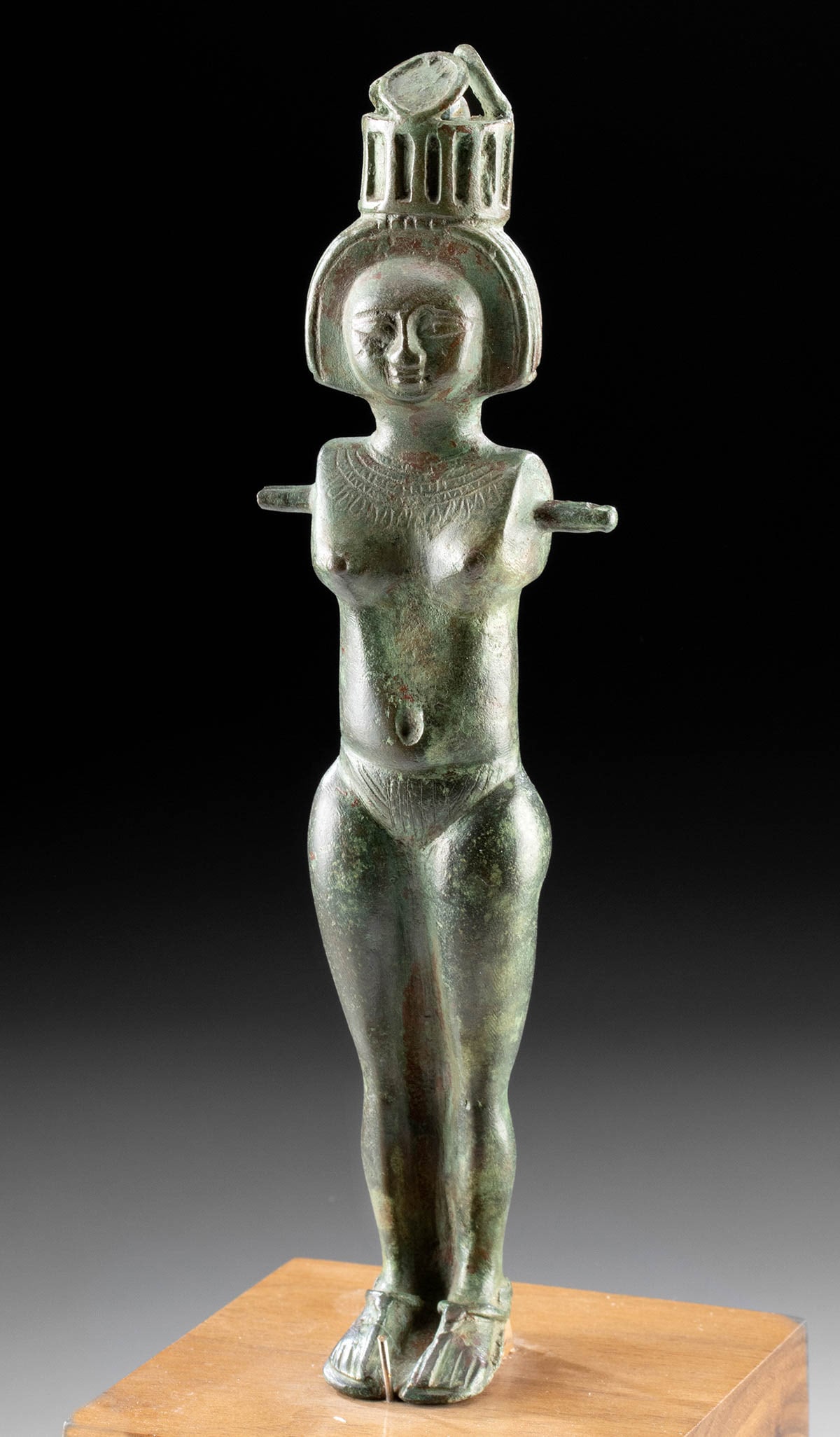 Egyptian Bronze "God's Wife of Amun," ex-Christie's: Ancient Egypt, late Third Intermediate Period, Kushite, 25th Dynasty, ca. 744 to 656 BCE. A cast-bronze female figure, nude and standing with closely-held legs, known as a God's Wife of Amun. She pres