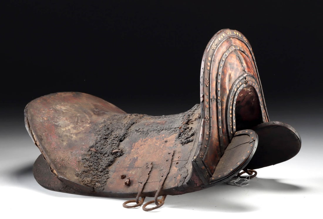 Early Tibetan Wooden Horse Saddle with Bone Inlay: Central Asia, Tibet, ca. 19th to early 20th century CE. An antique wooden horse saddle showing extensive age and signs of use, with old repairs where pieces have worn or broken over time. The upright