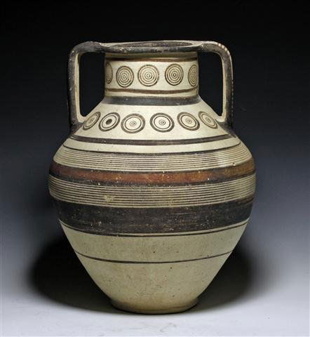 An Early Cypro-Mycenaean Bichrome Amphora: Late Bronze Age, Ca 1300-1100 BCE. Large painted pottery jar with two handles attached to rim from shoulders of vessel. Stands on a slightly raised platform and is painted with linear and geometric de