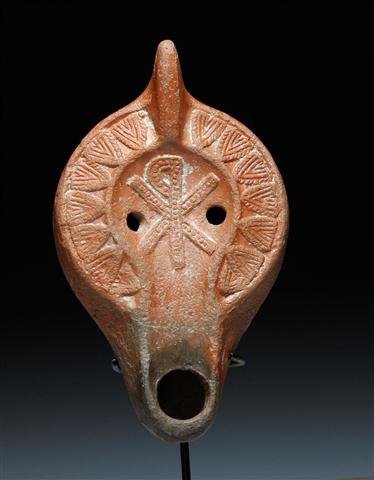 A Roman Redware Lamp with Chi-Rho: Carthage, North Africa, Roman Empire, Ca. 4th Century CE. Large terracotta oil lamp with the Chi-Rho (Symbol for Christ) prominently featured on top, surrounded by menorahs along the side of lamp. Evi
