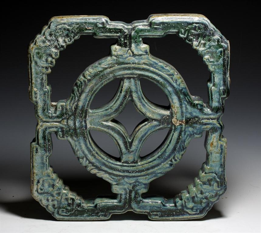 A Chinese Ming Dynasty Openwork Tile: China, Ming Dynasty, Ca. 15th Century CE. Large pottery open-work window in floral pattern, covered in deep green glaze, now with light touches of iridescent surface. 13-1/8" x 12-3/4". Provenance: Ex