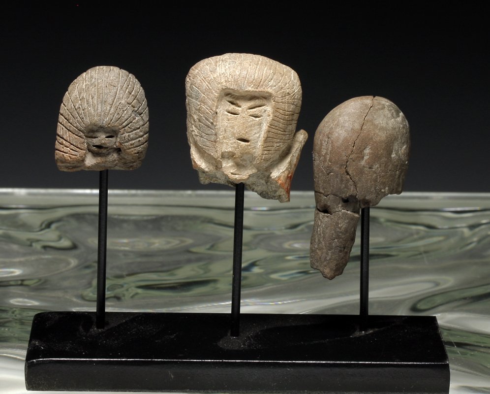 Three Early Valdivian Terracotta Heads: Pre-Columbian, Ecuador, Valdivia culture, ca 2500 to 2000 BCE. Set of three small pottery heads coming from "Venus" figures. Two with detailed facial features, the third almost plain and probably a ve