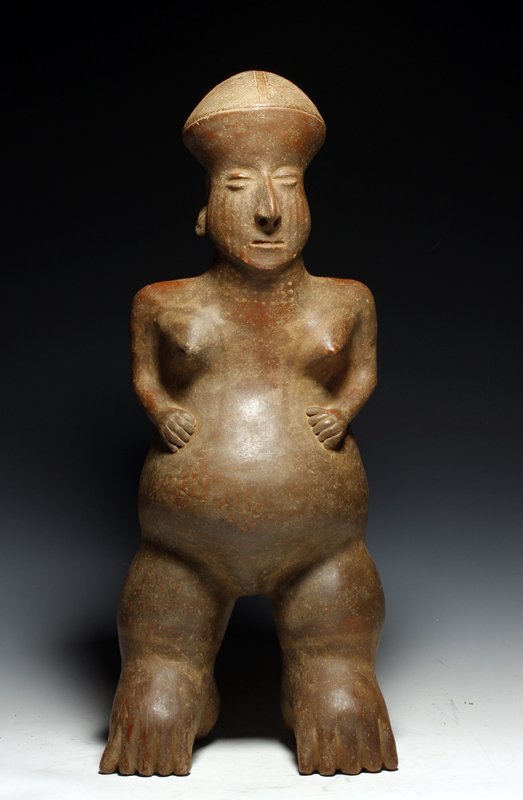 A Huge Jalisco San Sebastien Pottery Female: Pre-Columbian, Jalisco, west Mexico, ca 200 BCE - 200 CE. Standing nude terracotta female, shown with very large stomach, legs and feet, upper body normal in size. She has tattooing on her face, chest