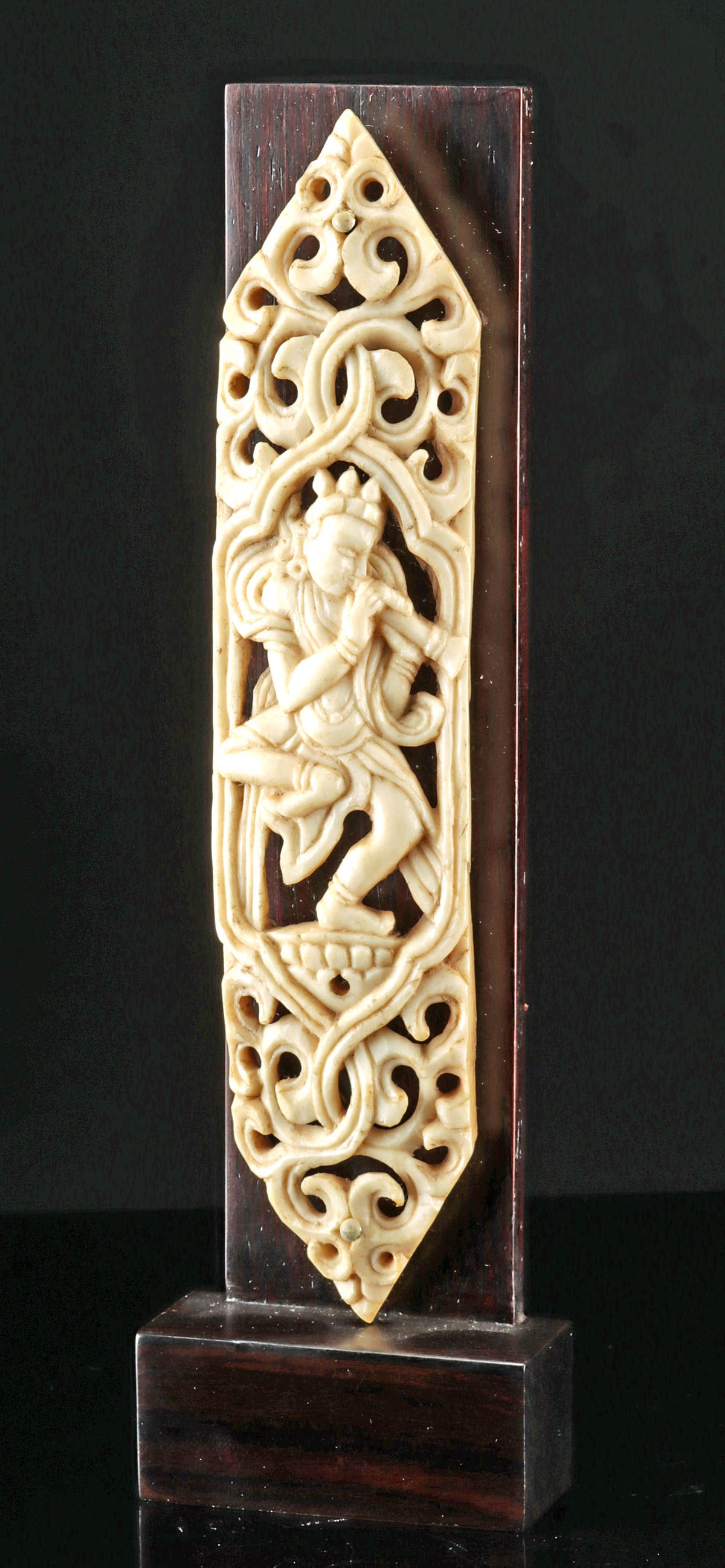 Tibetan Bone Apron Plaque of Dancing Musician: Central Asia, Tibet / Nepal, ca. 20th century CE. A hand carved human bone plaque with intricate openwork, depicting a dancing deity or attendant figure playing an instrument, perhaps a kangling. This