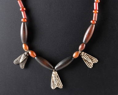 Carnelian Necklace w/ Ancient Egyptian Silver Fly Amulets: Ancient Egypt, Late Dynastic to Ptolemaic Period, ca. 664 to 30 BCE. A necklace featuring a strand of modern carnelian and glass beads, centered with three ancient silver fly pendants. The components