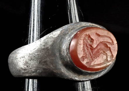 Roman Silver Ring w/ Carnelian Intaglio of Lion: Roman, Imperial period, ca. 1st to 3rd century CE. A striking example of Roman Imperial artistry, this silver ring is set with a finely carved carnelian intaglio portraying a lion in mid-turn - its mu