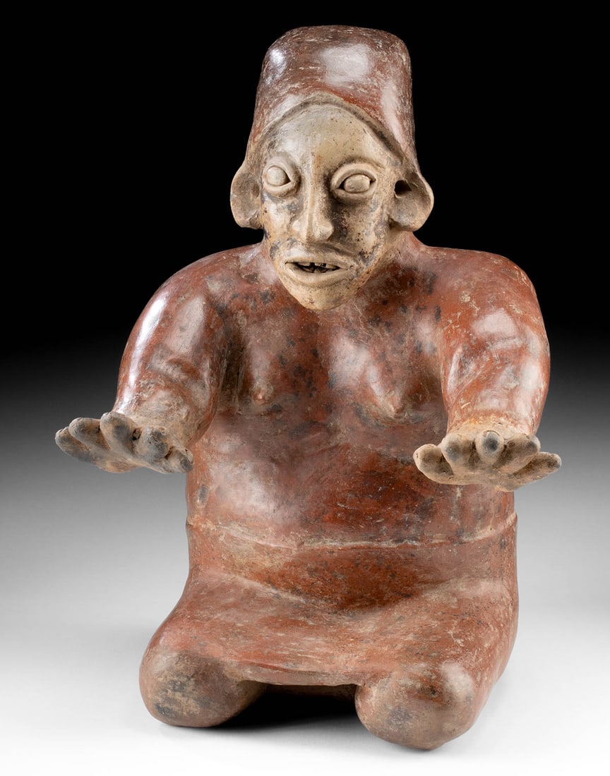 Jalisco Semi-Nude Female Figure - Kneeling Guardian: Pre-Columbian, West Mexico, Jalisco, Ameca-Ezatlan type, ca. 100 BCE to 250 BCE. A powerful and enigmatic redware sculpture from the Jalisco Ameca-Ezatlan tradition, this semi-nude female figure comma