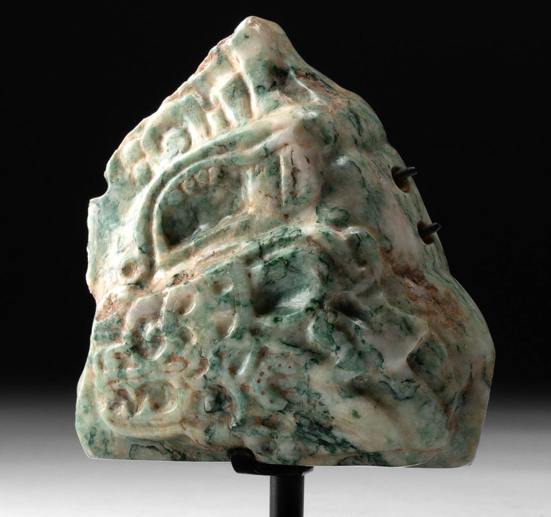 Maya Omphacite Jade - Jaguar Profile Carving: Pre-Columbian, Southern Mexico or Guatemala, Maya, Classic Period, ca. 250 to 900 CE. A remarkable fragment of carved omphacite jade depicting the stylized profile of a jaguar's head - an enduring sym