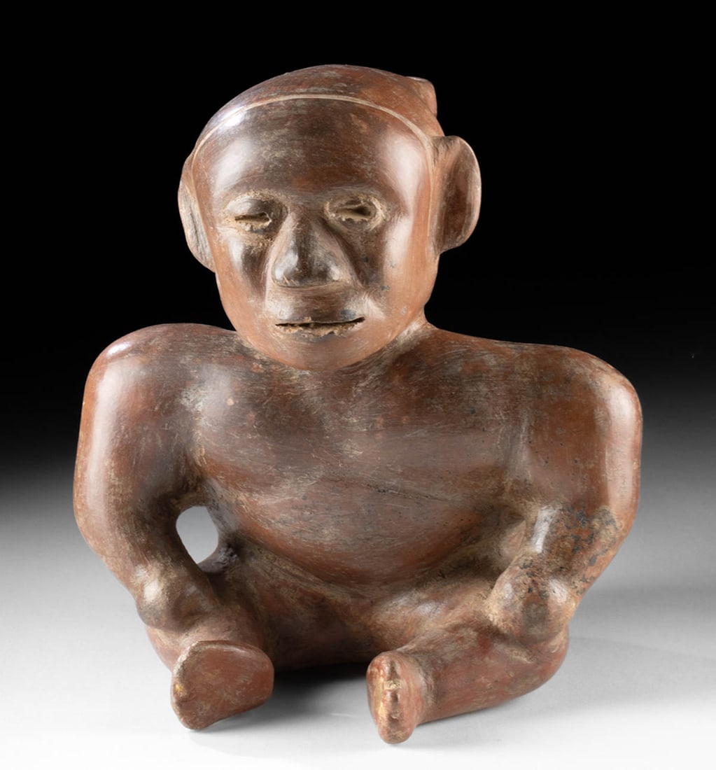Colima Redware Hunchback Dwarf Effigy Vessel: Pre-Columbian, West Mexico, Colima culture, Protoclassic to Early Classic period, ca. 100 BCE to 250 CE. A fine red-slipped pottery vessel in the form of a seated hunchback dwarf, an important figure