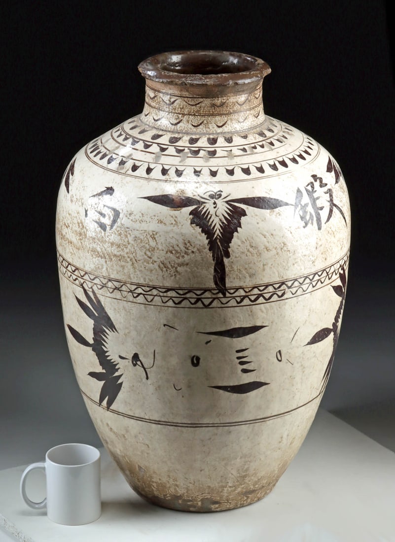 Large 16th C. Intact Chinese Ming Cizhou Ware Wine Jar: East Asia, China, Late Ming Dynasty, ca. 16th to 17th century CE. A massive pottery Cizhou ware wine jar (guan), decorated in the classic high-fired creamy white slip under a transparent glaze, then p