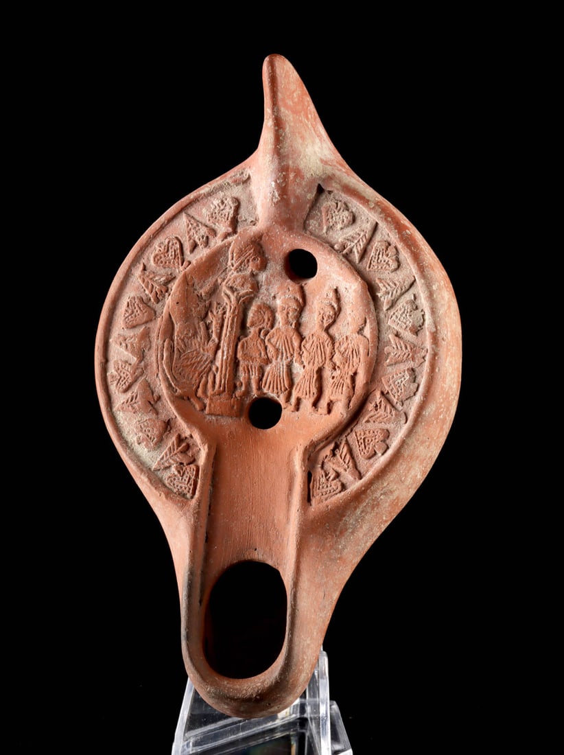 Roman Carthage Redware Oil Lamp - Seated Ruler: Roman Empire, made in North Africa, Carthage, 4th century CE. A finely molded red-slip terracotta oil lamp, notable for its richly detailed central scene depicting a seated ruler or deity attended by