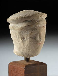 Cypriot Hellenistic Limestone Head of Man w/ Kausia Hat: Greece, Cyprus, Hellenistic Period, ca. 3rd century BCE. A splendid limestone head of a man or child wearing a Macedonia kausia, his face presenting a protruding brow, recessed eyes, a straight nose,