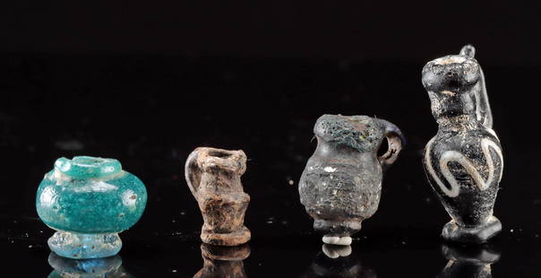 Four Miniature Greek and Roman Glass Vessels: Greek and Roman Empires, Hellenistic to Imperial, ca. 3rd century BCE to 2nd century CE. Fascinating group of tiny glass vessels! Largest is a deep blue, but appearing mostly as black core-formed