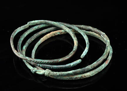 Four Ancient Bronze Bracelets: North Africa, Roman or earlier, ca. 500 BCE to 200 CE. Nice set of four bronze bracelets, all of thin rounded form. Two bracelets are solid and require they slip over one's hand and wrist, the other