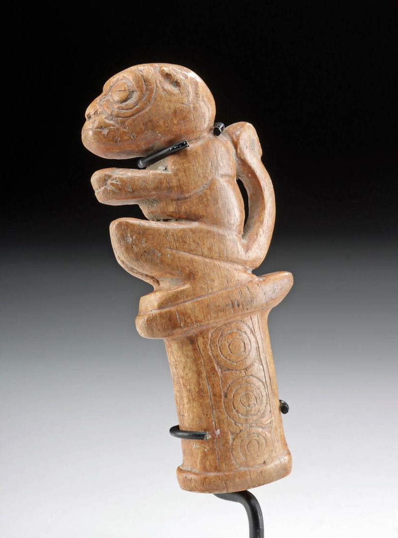 Sinu Bone Finial - Stylized Monkey Bullseye Motifs: **Originally Listed At $400** Pre-Columbian, Colombia, Sinu (Zenu) peoples, ca. 800 to 1200 CE. A hand-carved bone finial depicting a stylized monkey crouching with lengthy hind legs atop the base of