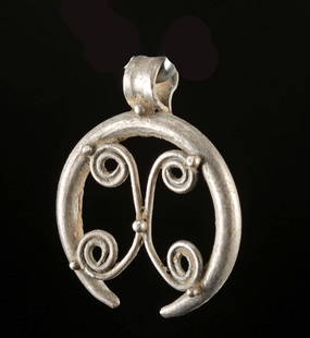 Viking Silver Pendant - Openwork Scroll Design: Northern Europe, Scandinavia, Viking, ca. 9th to 11th century CE. A delicately forged Viking silver pendant formed from a single circular band that gracefully flares open at the base, cradling a scrol