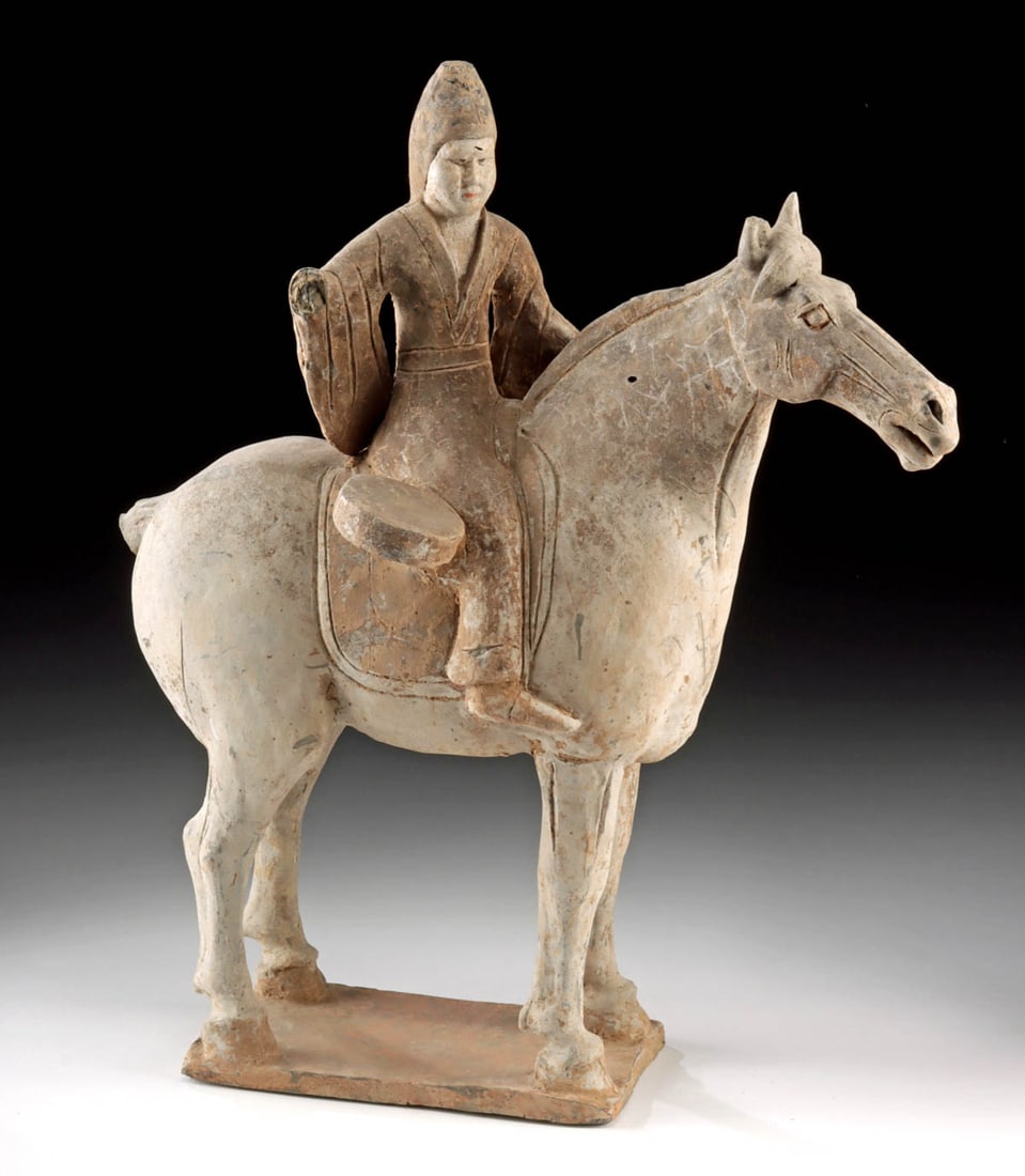 Tang Dynasty Pottery Horse and Drummer Figure: East Asia, China, Tang Dynasty, ca. 618 to 907 CE. A strikingly modeled pottery figure of a horse and rider from the Tang Dynasty, capturing a ceremonial drummer mid-ride with a presence both solemn a