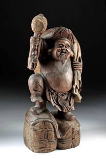 Japanese Meiji Wood Mingei Figure (of Daikoku): East Asia, Japan, Meiji era, ca. early to mid-20th century CE. This large wooden mingei (folk art) carving depicts Daikokuten (Daikoku), one of the Seven Lucky Gods, standing joyfully atop two rice ba