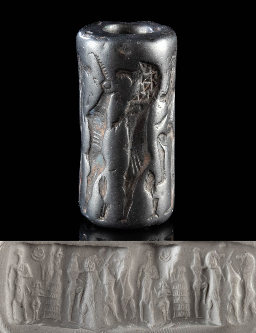 Mesopotamian Hematite Stamp Seal w/ Gods & Lions: Ancient Near East, Mesopotamia, Old Babylonian Period, ca. 1900 to 1600 BCE. Carved from dense black hematite with a mirror-like sheen, this Old Babylonian cylinder seal bead offers a mythic vision re