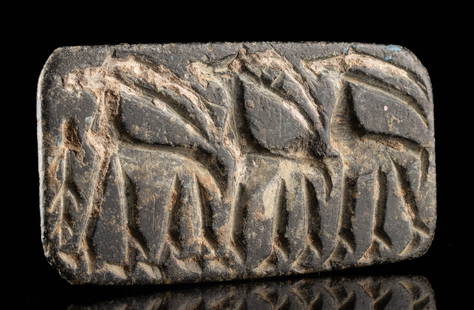Anatolian Chalcolithic Stone Stamp Seal w/ Gazelles: Near East, Anatolia, Chalcolithic era, ca. 4000 to 3000 BCE. A dark stone wedge or gable-shaped stamp seal deeply etched with a procession of three horned quadrupeds - likely gazelles - depicted in pr