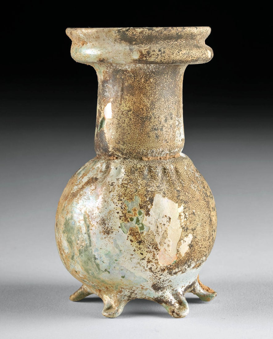 Exhibited Roman Glass Footed Sprinkler Flask, Rare Form: Roman, Imperial period, Eastern Empire, ca. 1st to 3rd century CE. A gorgeous glass sprinkler flask of a rare form with a globular body set on 5 petite feet, surmounted by a thick neck and broad, lipp