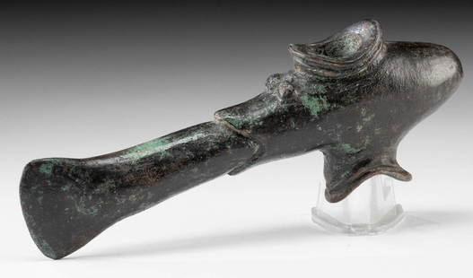 Ancient Luristan Bronze Zoomorphic Axe Head: Near East, northwestern Iran / eastern Turkey, Luristan, ca. 1200 to 800 BCE. A cast bronze axe head featuring a stylized form evocative of a reptilian or piscine creature with a socketing hole for mo