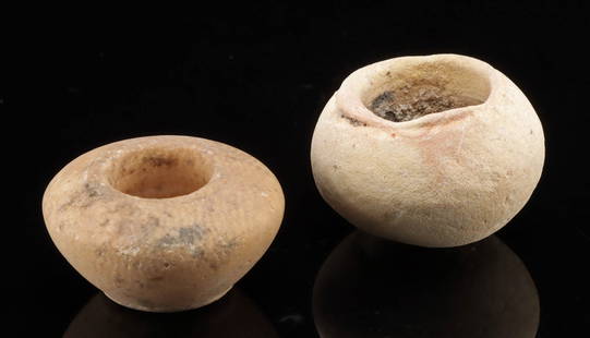 Ancient Egyptian Pair of Carved Stone Cosmetic Pots: Egypt, Third Intermediate Period, dynasties 21 though 25, ca. 1070 to 664 BCE. This pair of miniature vessels includes one carved from striated alabaster and another from a chalky white stone, likely