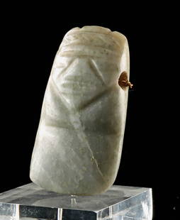 Costa Rican Pre-Columbian Greenstone Axe God Pendant: Central America, Costa Rica, Greater Nicoya region, circa 500 to 1000 CE. A carved greenstone axe god pendant, depicting an abstract anthropomorphic figure. The figure's form emerges from the celt-sha