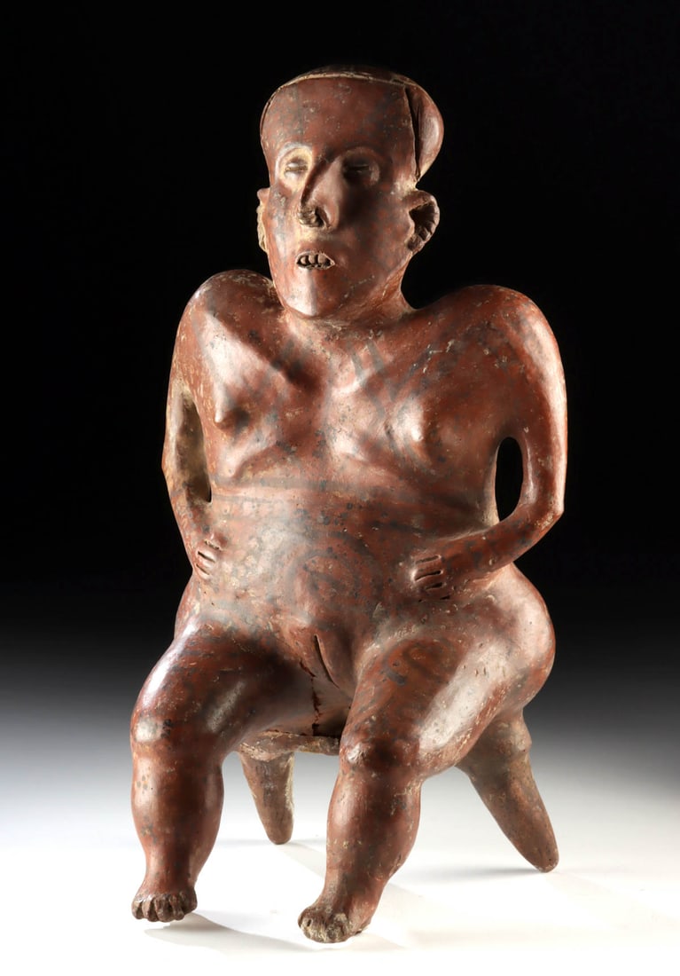 Large Nayarit Shaft Tomb Pottery Seated Female Figure: Pre-Columbian, West Mexico, Nayarit, ca. 300 BCE to 300 CE. A large hollow pottery seated female figure rendered with a broad, square torso, seated atop a two-legged stool. Her body is decorated with 
