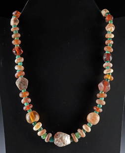 Ancient Glass Green & Amber Hued Beaded Necklace: Roman, Imperial Period, ca. 1st to 4th century CE; Eastern Mediterranean, Phoenician, ca. 600 to 300 BCE; Near East, Islamic Period, ca. 500 to 1000 CE. A luminous strand of ancient glass beads, beaut