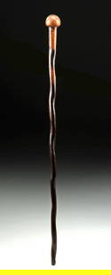 South African Zulu Wood Knobkerry Staff: Southern Africa, Zulu culture, ca. 1900s CE. A short wooden curving knobkerrie with a rounded bulbous head and a slender, twisted shaft. The surface shows a warm aged patina with wear from use. Likely