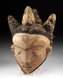 Congolese Pende Chief Mask with Raffia Headdress: Central Africa, Democratic Republic of the Congo, Pende, ca. early 20th century CE. A wood mask featuring a raffia-cloth-covered coiffure rising into four conical forms, stitched with blackened vegeta