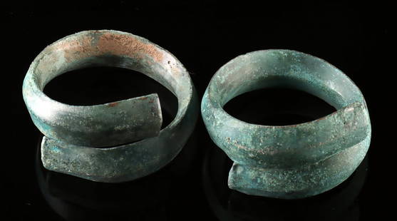 Dong Son Bronze Coiled Arm Cuffs - Pair: Southeast Asia, Vietnam, Dong Son Culture, ca. 500 BCE to 100 CE. A sculptural pair of ancient elegance, these bronze coiled arm cuffs from the Dong Son culture spiral with commanding grace. Each cuff