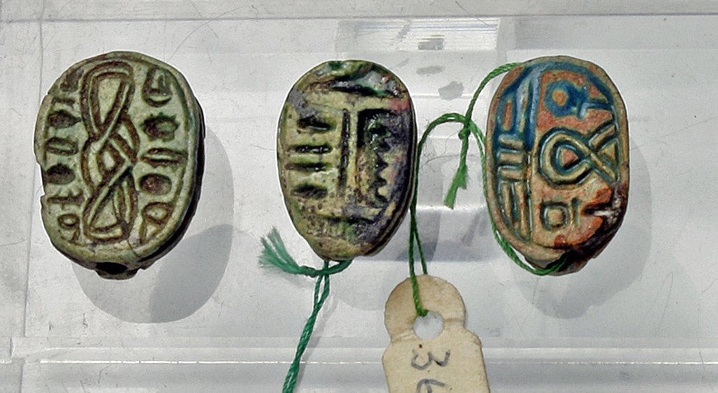 A Grouping of Three Egyptian Scarabs: Egypt, Late Dynastic Period, Beginning - Middle 1st Millennium BCE. A group of three Egyptian faience scarabs, each with hieroglyphs on the bottom. Would make excellent pendants on a necklace. Just un
