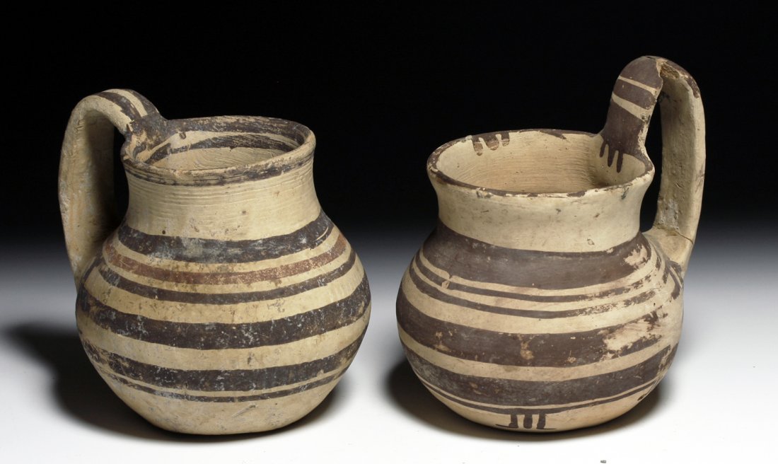 A Pair of Published Daunian Olpes: Southeastern Italy, Ca 4th century BCE. Two pottery vessels uncovered in a Daunian tomb in 1944 by Byron Farwell, and later (1953) published in a book on his collection. First, an olpe decorated in da