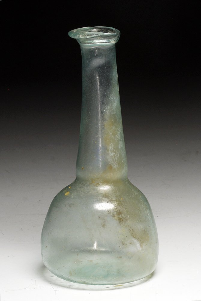 Roman Glass Bottle - Intact, 5-3/8"H: Roman Empire, Ca 200 to 400 CE. Lovely medium-sized unguent vessel, of pale aqua-blue glass; with bulbous base, long tapered neck and rolled rim. Interestingly, the rim was slightly misshapen during t