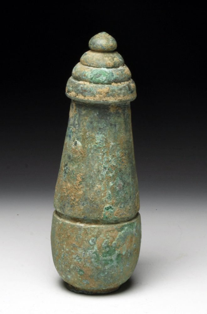 A Large Khmer Bronze Lime Pot: Cambodia, Ca. 12-14th Century CE. large bronze lime pot composed of two parts, separating at middle with hollow interior for lime storage. Sits on raised platform and has bud on top. Lime still eviden