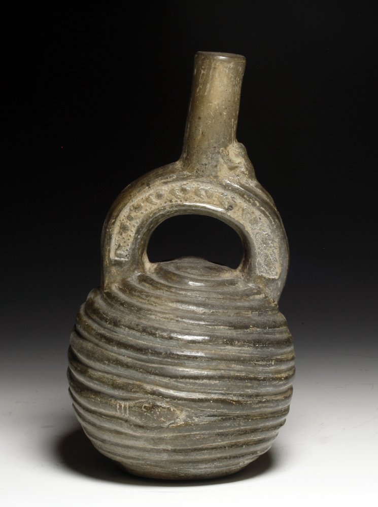 Pre-Columbian Chimu Stirrup Vessel w/ Snakes: North coastal Peru, Ca 1000 to 1400 CE. Fine blackware pottery vessel; body in circular form with slithering snakes encircling the lower section, two bands of birds on the stirrup and small monkey clu