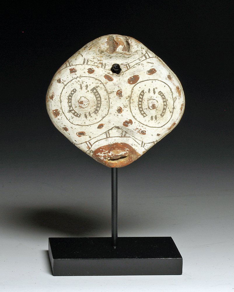 A Pre-Columbian Redware Marajoara Maskette: Marajo Island, Para Brazil, ca. 400-1300 A.D. Redware pottery maskette, evidently from a very large vessel, in abstract zoomorph form. Animated face with extended red lips and large round eyes, incisi