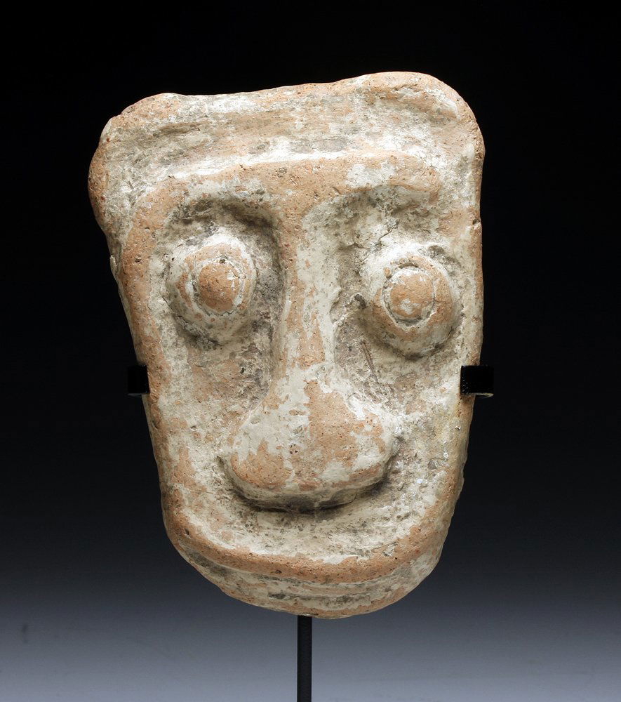A Pre-Columbian Marajoara Mask: Marajo Island, Para Brazil, ca. 400-1300 A.D. Redware pottery maskette, evidently from a very large vessel, in abstract human form, intact and with light root marks and deposits. 4-1/2" H, not includi