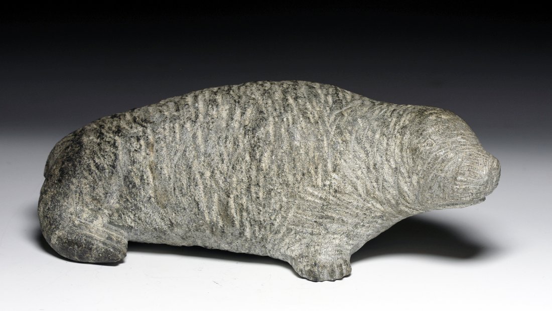 An Inuit Eskimo Seal Stone Sculpture: Alaskan Territory, Ca. 1940 CE. A carved sculpture in soapstone, with incised facial detail. Carving marked mimic seal's natural skin folds. 6-3/4"L. Provenance: Ex-Byron Farwell Collection. Authentic