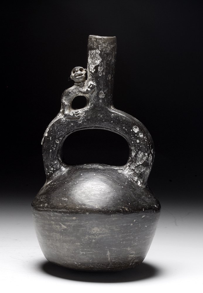 Chimu Pre-Columbian Blackware Stirrup: Northern Peru, Ca 1000 to 1400 CE. Cute blackware stirrup jar, smaller than normal size, detailed monkey standing atop stirrup spout. 7" H. PROVENANCE: EX- Mary Powell collection acquired in Peru in t