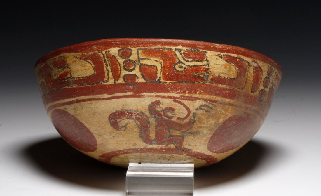 Maya Copador Monkey Bowl: El Salvador, Ca 500 to 900 CE. Large polychrome bowl decorated on the exterior with repeating pseudo glyphs along top and three playful monkeys and three large red balls toward the base; inside decora