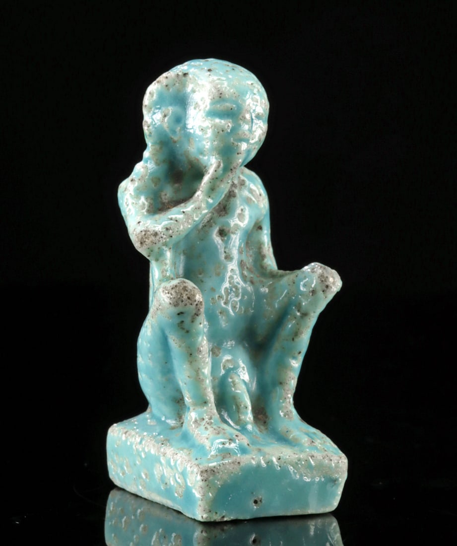 Egyptian Faience Nude Harpokrates Amulet: **Originally Listed At $300** Egypt, Late Dynastic to Ptolemaic period, ca. 672 to 30 BCE. A delightful and quite rare faience amulet depicting the child-god Harpocrates seated on a rectangular plinth