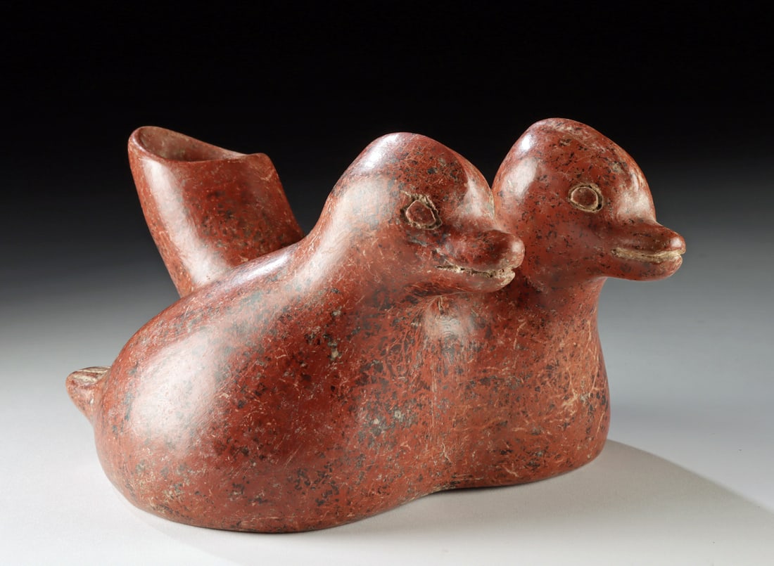 Colima Ceramic Effigy - Two Conjoined Ducks: Pre-Columbian, West Mexico, Colima, ca. 300 BCE to 300 CE. A charming and skillfully modeled redware pottery vessel in the form of two conjoined seated ducks. Each bird is rendered with plump, rounded