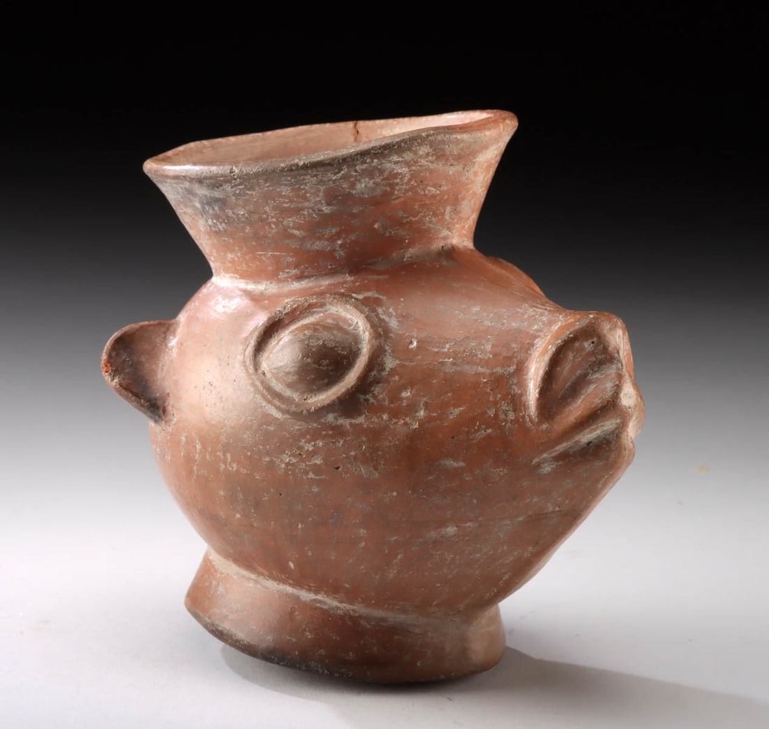 Moche Redware Vessel in the Form of a Llama Head: Pre-Columbian, Moche, North Coast of Peru, ca. 100 to 700 CE. A finely modeled Moche pottery vessel in the form of a llama head, rendered in a rich burnished redware. The vessel takes the stylized sha