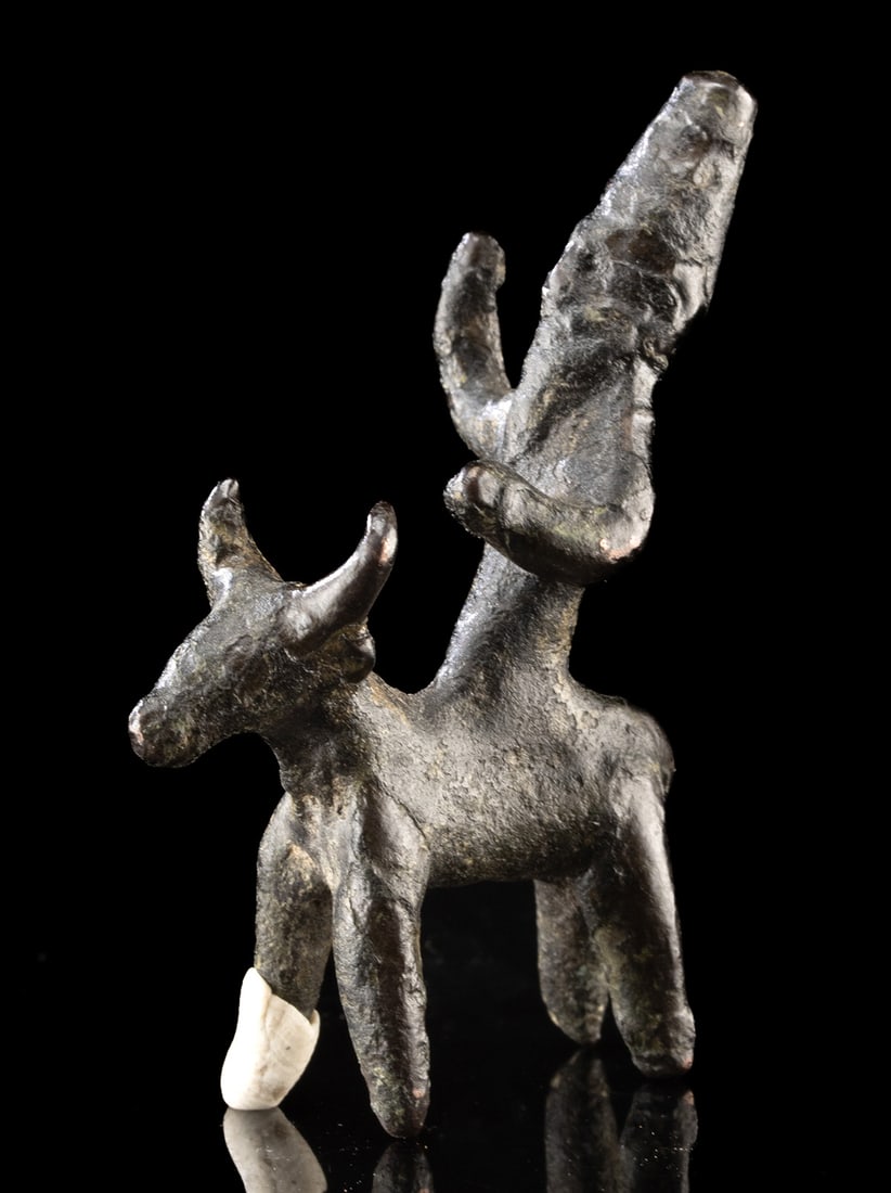 Bronze Age Canaanite Copper Figurine of Man on Bull: Ancient Near East, Levant, Canaanite, ca. 14th to 13th century BCE. A rare and powerful copper figurine depicting a bearded male figure with an elongated conical headdress, mounted astride a bull. The