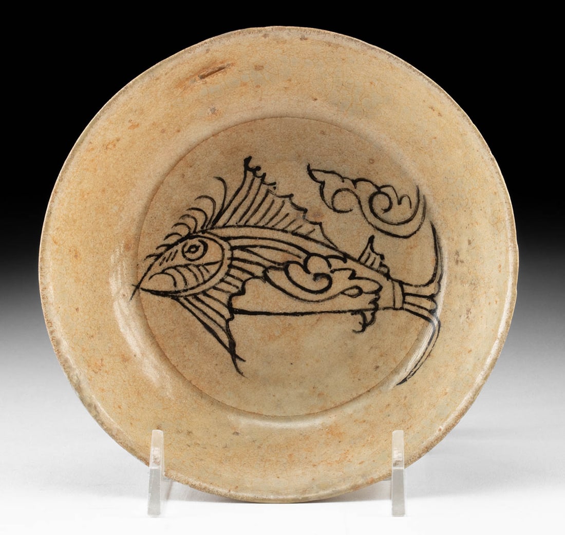 14th C. Sukhothai Porcelain Plate with Fish Design: Southeast Asia, Thailand, Sukhothai Kingdom, ca. 14th to 15th century CE. A beautifully balanced porcelain plate from the Sukhothai kilns, its interior adorned with a spirited depiction of a fish swim