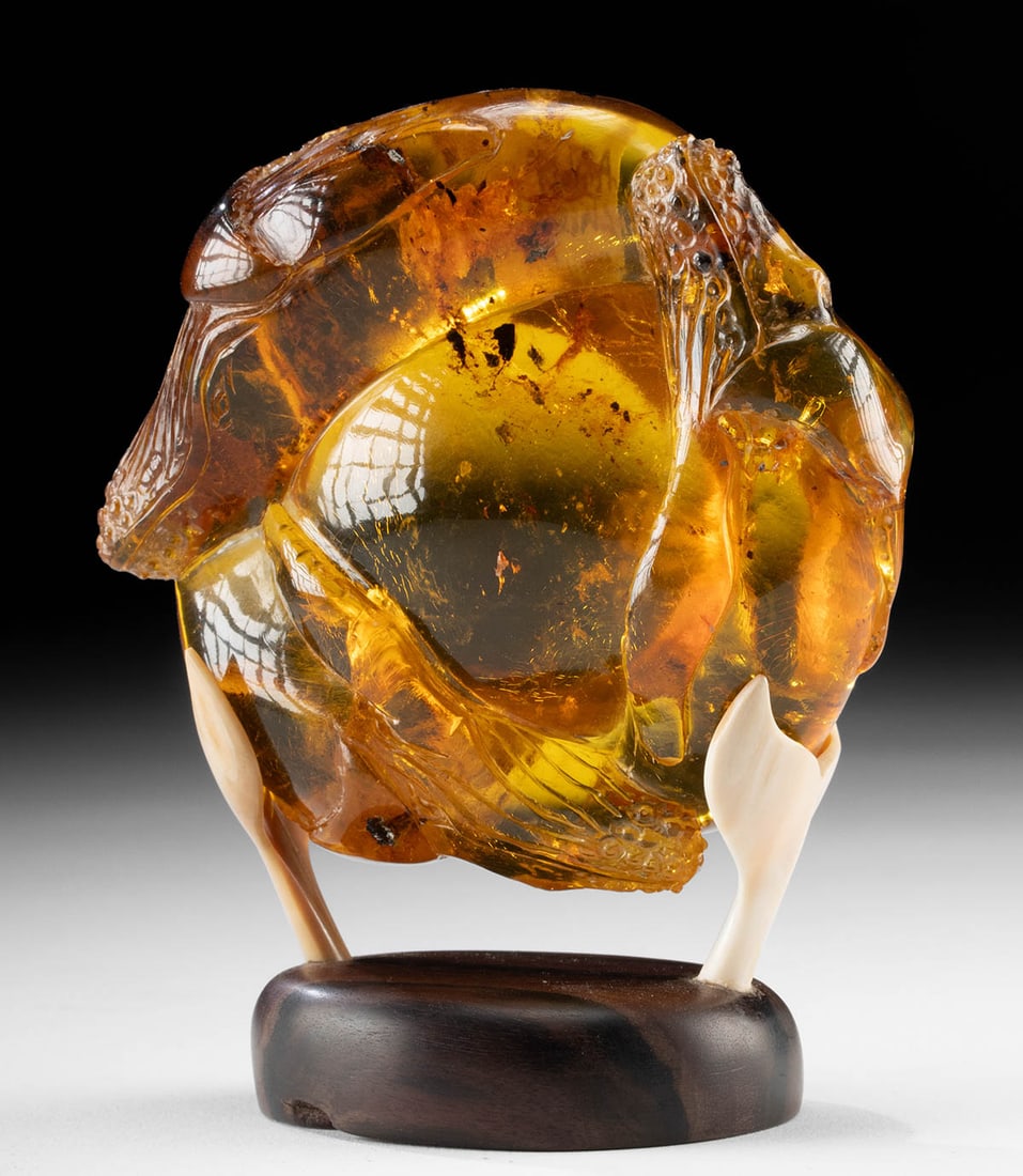 Chiapas Amber Carving Humpback Whales on Ivory Base: Mexico, Chiapas / United States, ca. 21st century CE. A superb specimen of translucent golden amber, richly hued in fiery orange and honey tones, with natural inclusions suspended within its interior.